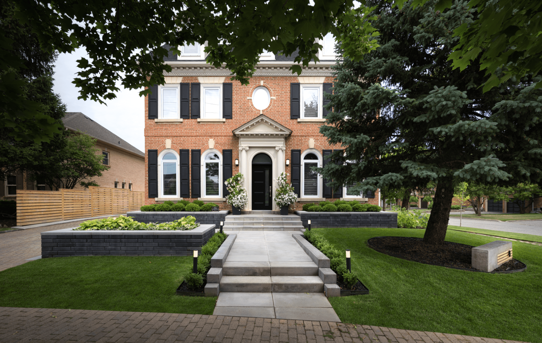 Full landscaping of a frontyard with a walkway, lighting, and lawn